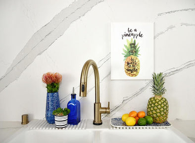 Pineapple canvas print with inspirational quote hanging over kitchen sink