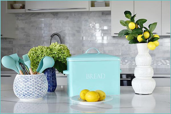 Vintage farmhouse bread bin in mint on counter with utensil holder, lemons, white vase and hydrangea flowers