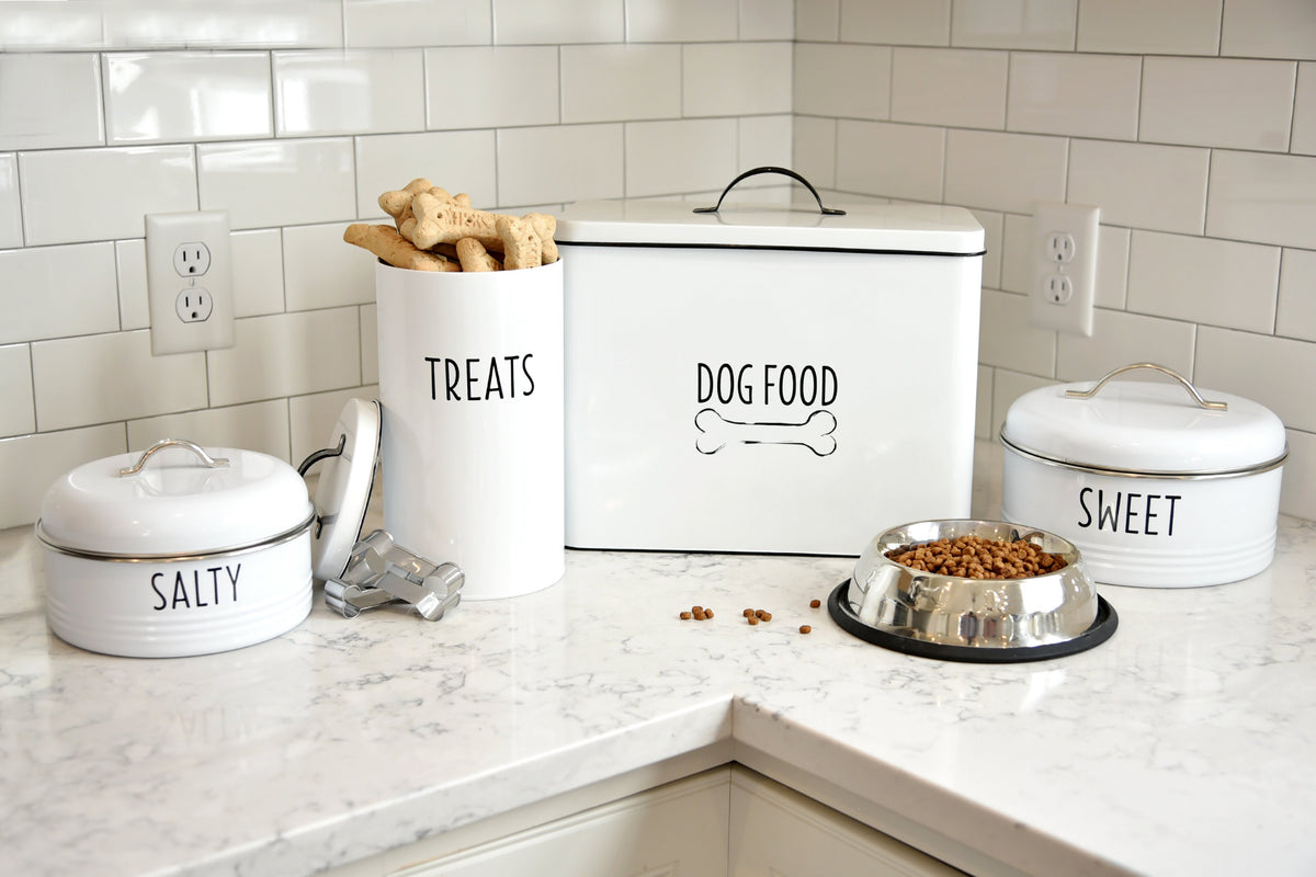 White vintage farmhouse snack canisters, pet treat container and dog food bin on white counter. 